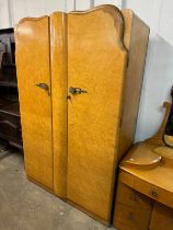 An Art Deco birds eye maple bedroom suite, comprising; two wardrobes and a dressing table