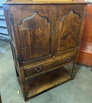 A George III style Ipswich oak cupboard on stand