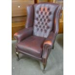 A burgundy leather Chesterfield wingback armchair