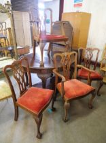 An Edward VII Chippendale Revival carved mahogany extending dining table and four chairs