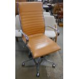 An Eames style chrome and tan leather revolving desk chair
