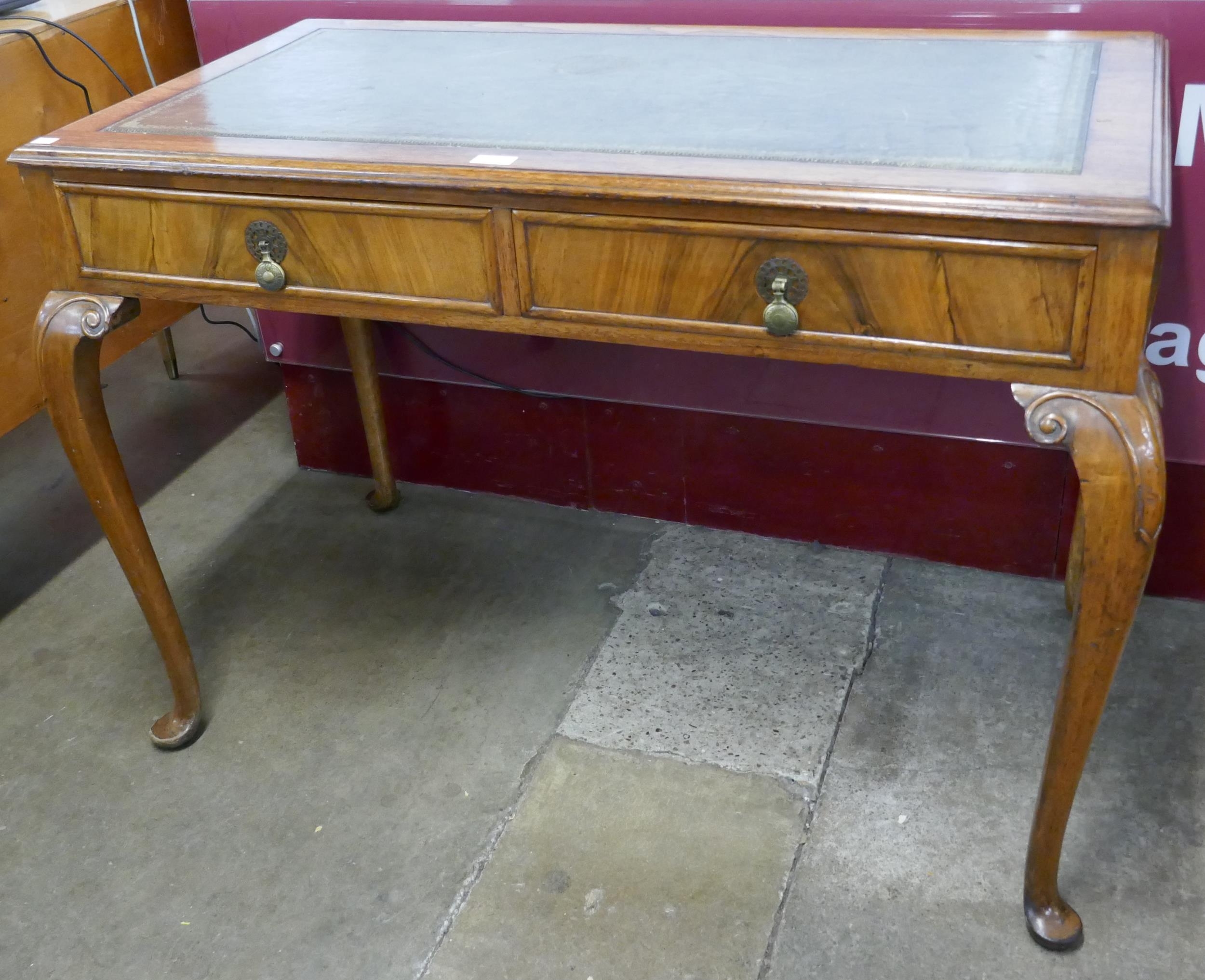 A Queen Anne walnut and green leather topped two drawer writing table