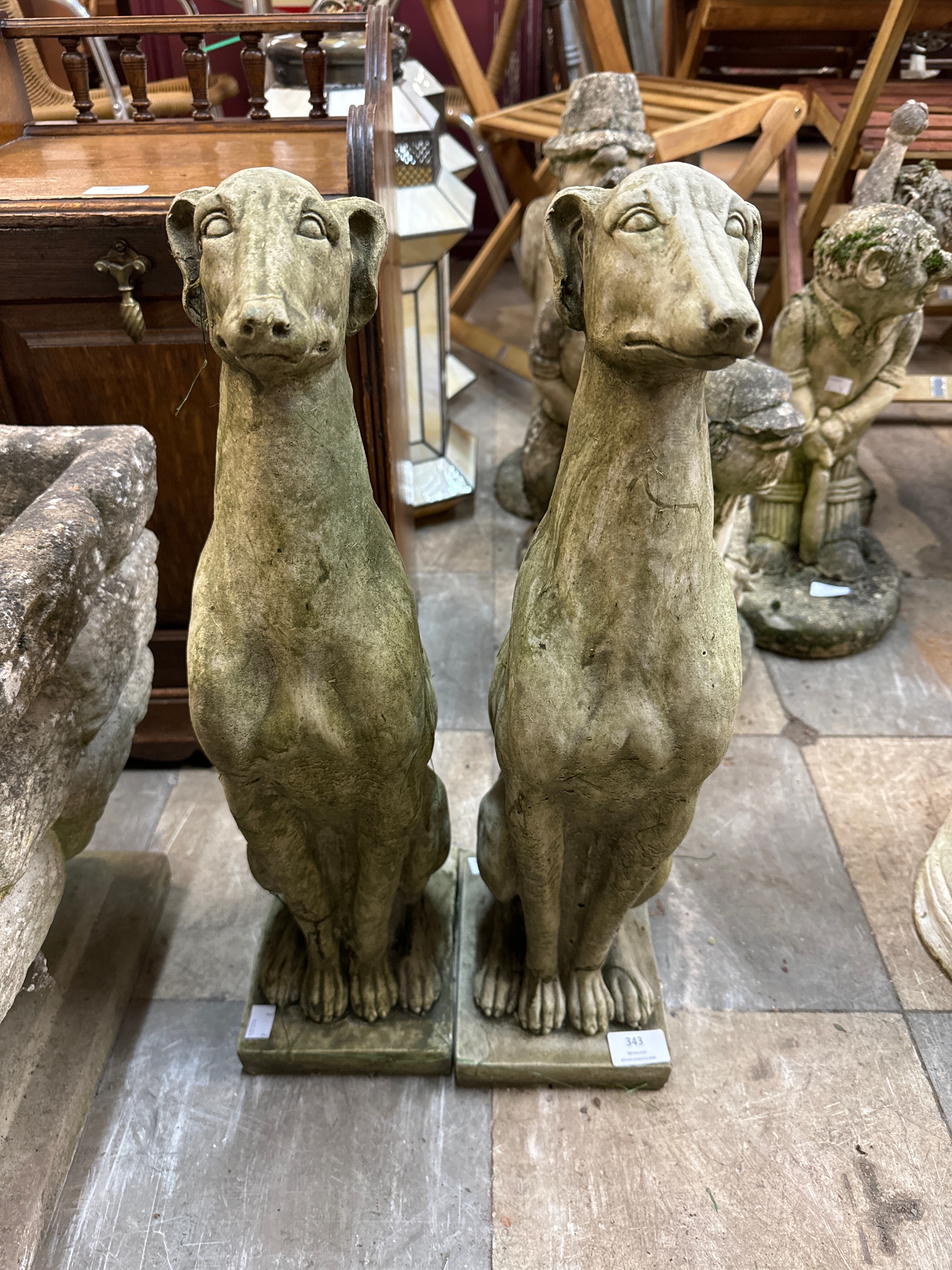 A pair of concrete garden figures of seated greyhounds