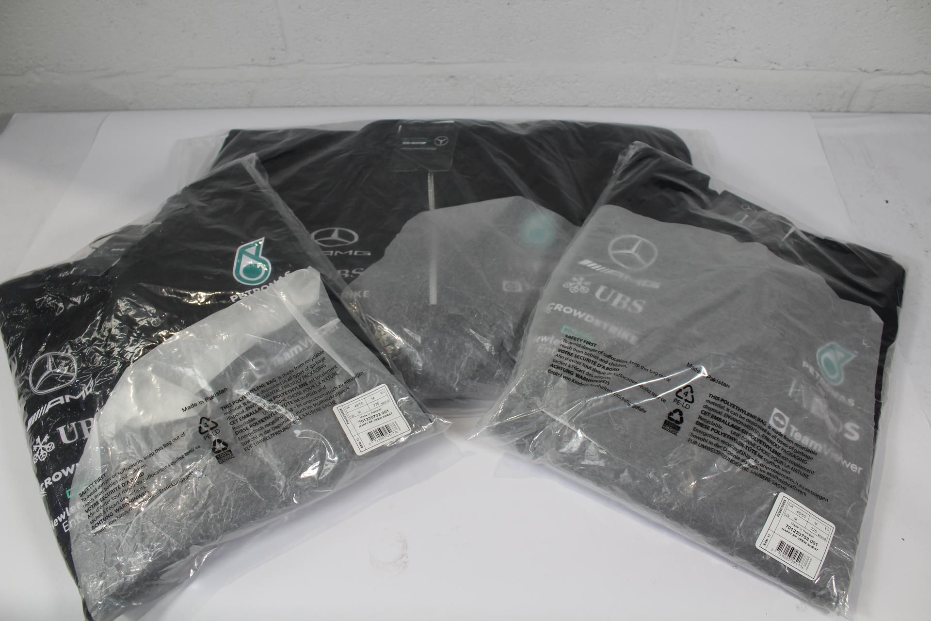 Two men's Mercedes AMG Petronas Motorsport F1 blac