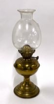 A brass oil lamp with glass chimney