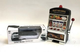 A Land Rover Range Rover Sport 1:18 scale remote control car, together with a toy slot machine