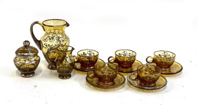 A Bohemian amber glass tea set with hand painted silvered finish, comprising five cups and