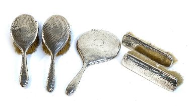 An Edwardian planished silver dressing table set, Chester 1907, comprising two hair brushes, two
