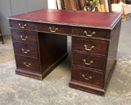 A 19th century pedestal desk, with red leather skiver, over nine drawers, on a plinth base,