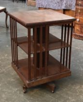 An Edwardian rotating mahogany bookcase, on ceramic casters, 50x50x75cmH