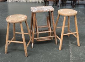 A pair of beech and elm kitchen stools with circular seats, each 56cmH; together with a further