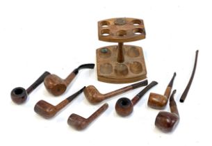 A collection eight tobacco pipes, one with silver collar, with a stand