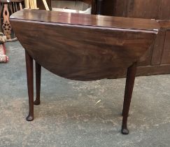 A George II mahogany drop leaf table, with single end drawer, on turned tapering legs and pad
