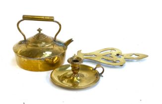 A 19th century brass kettle, candlestick and a trivet