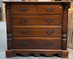 A large mahogany chest of two short over three long drawers, flanked by spirally fluted half