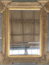 A gilt gesso wall mirror with bevelled plate, 105x80cm