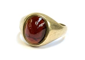 A 9ct gold ring set with a garnet cabochon, hallmarked for Birmingham 1972, size L, 2.9g
