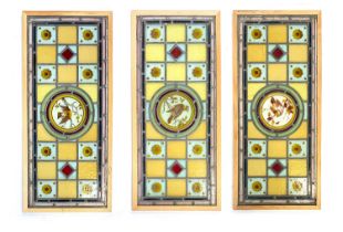 Three Arts and Crafts stained glass panels, each with central roundel hand painted with a bird