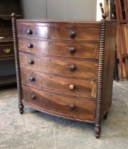An early 19th century bowfront mahogany chest of two short over four graduating drawers, flanked
