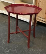 An octagonal red lacquer table on folding base, 60cm wide