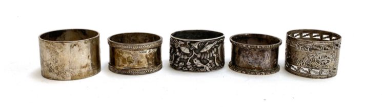 A white metal napkin ring, chased with various fish and crabs; together with four other hallmarked