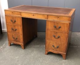 A 20th century pedestal desk, tooled leather skiver over nine drawers, 122x68x77cmH