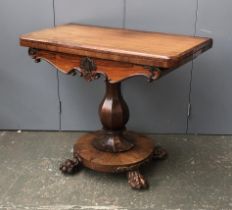 A 19th century rosewood card table, on octagonal faceted baluster column, on four well carved paw