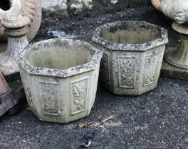 A pair of octagonal composite stone planters with acorns and leaf motif, each 35cmWx28cmH