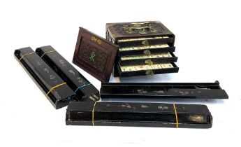 A Chinese carved hardwood cased set of mahjong with bone and bamboo pieces; together with playing