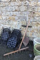 A mixed lot of vintage gardening tools; a large wooden rake, three pronged metal instrument, and
