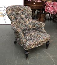 A Victorian button back armchair on turned ebonised legs, upholstered in a William Morris print