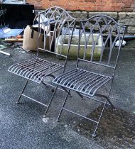 A pair of folding metal garden chairs