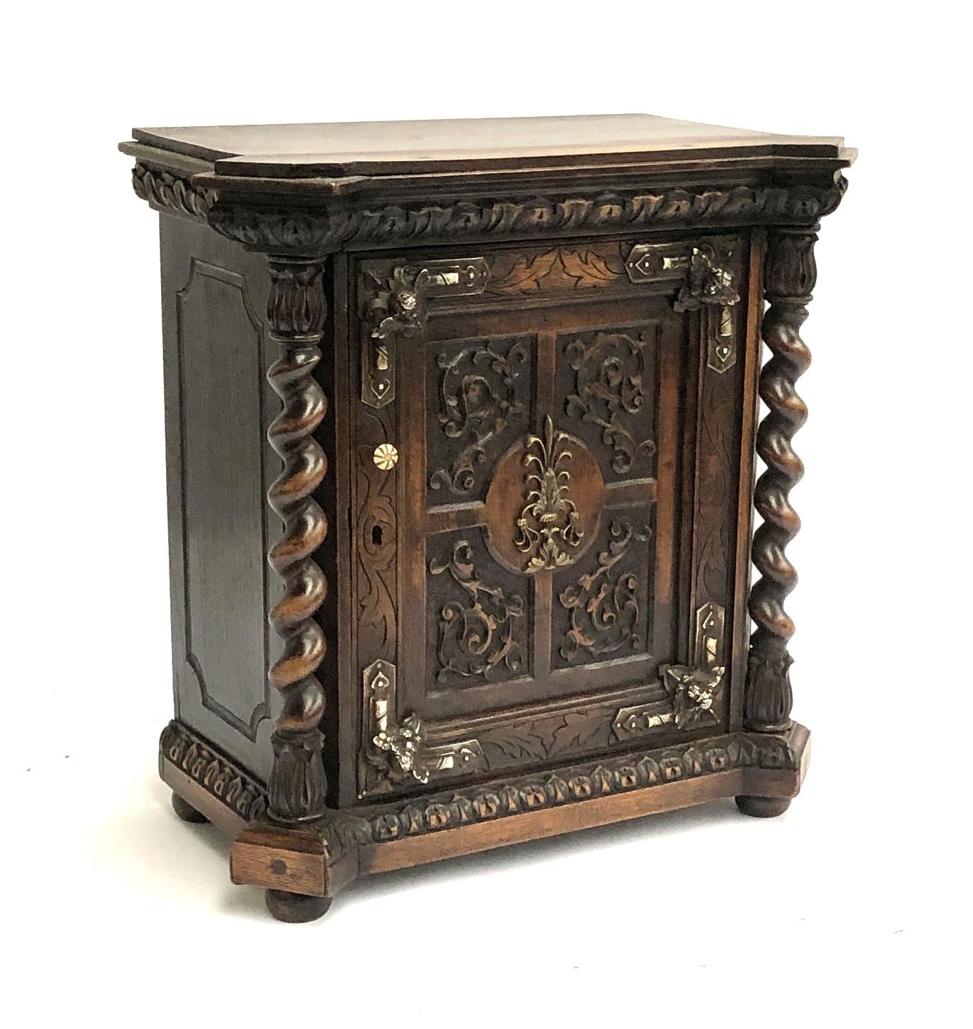 A 20th century carved reliquary cupboard in 17th century style, opening to a single drawer,