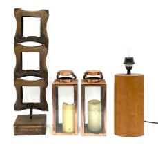 A mixed lot comprising a three tier metal candle holder, 60cmH, two metal lanterns, and a wooden