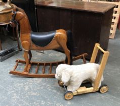 A 20th century carved rocking horse, 105cmL; together with a push along dog toy