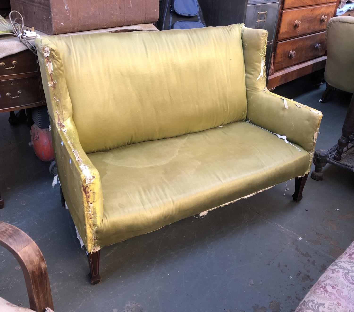 An Edwardian wingback settee upholstered in green silk, 130cmW