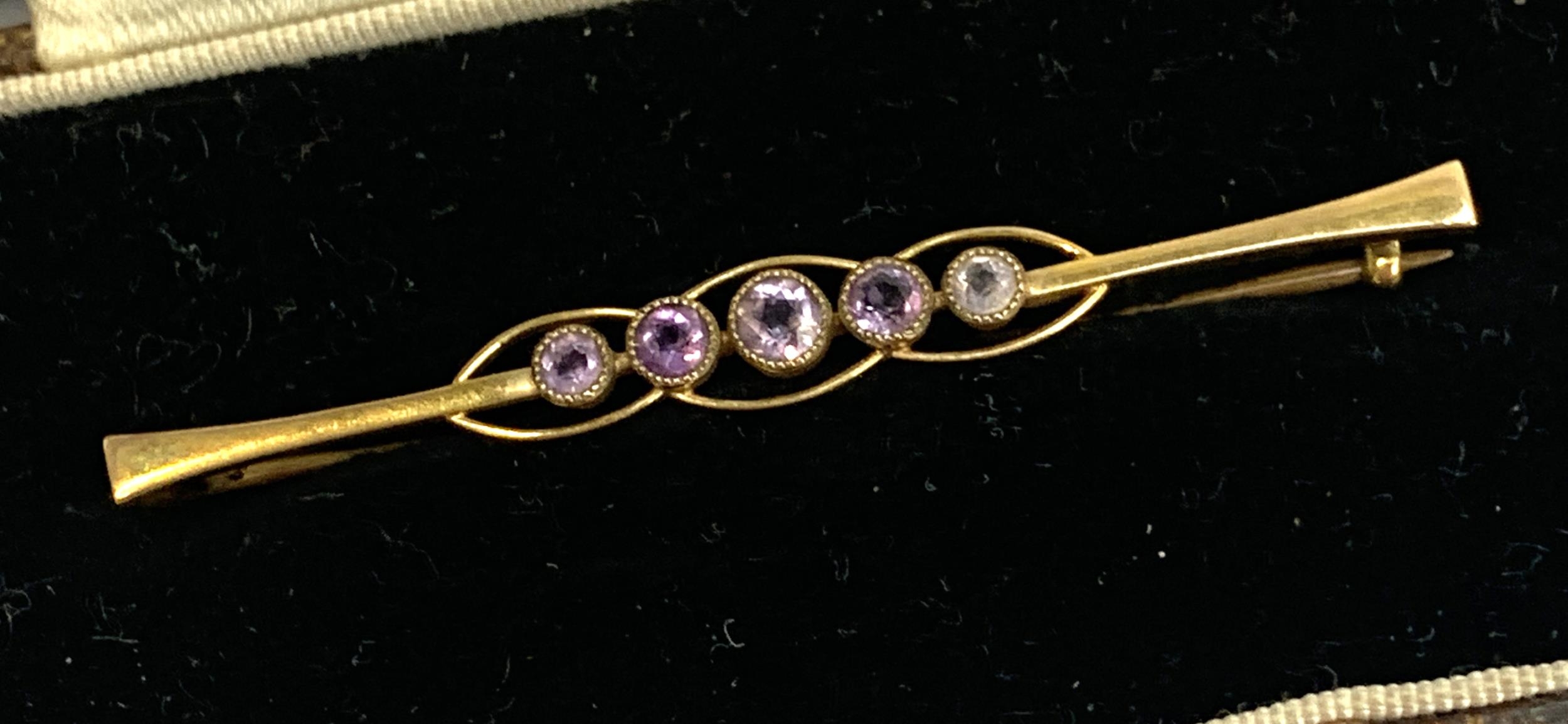 A 9ct gold Edwardian bar brooch set with five amethysts in milgrain settings, 5cmL, 1.9g, in box - Image 2 of 2