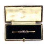 A 9ct gold Edwardian bar brooch set with five amethysts in milgrain settings, 5cmL, 1.9g, in box