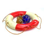 A large blue glass fisherman's float, two smaller amber glass floats, wooden ships wheel, and