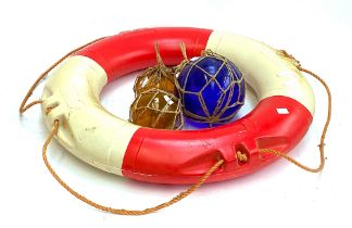 A large blue glass fisherman's float, two smaller amber glass floats, wooden ships wheel, and