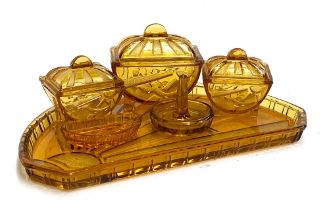 An Art Deco amber glass dressing table set with sunray design