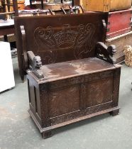 A 20th century carved oak monks settle, the seat with hinged lid, dimensions when closed 94x54x73cmH