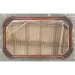 A rectangular wall mirror in carved oak frame, bevelled glass with canted corners, 75x46cm
