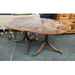 A Regency style D end dining table with radial yew veneer, on twin baluster columns and swept