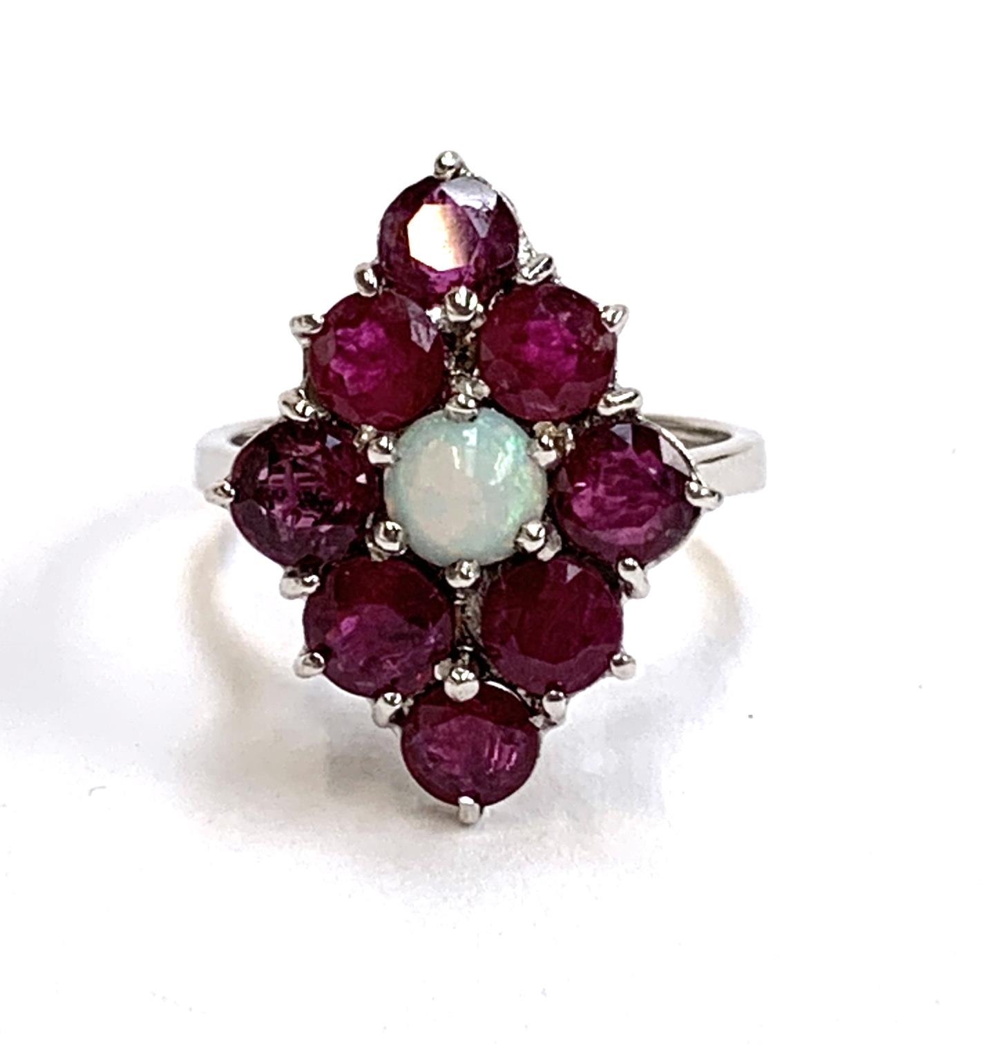 A 9ct white gold ring set with a navette form cluster of rubies and a central opal, size J, 3.2g