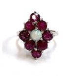A 9ct white gold ring set with a navette form cluster of rubies and a central opal, size J, 3.2g