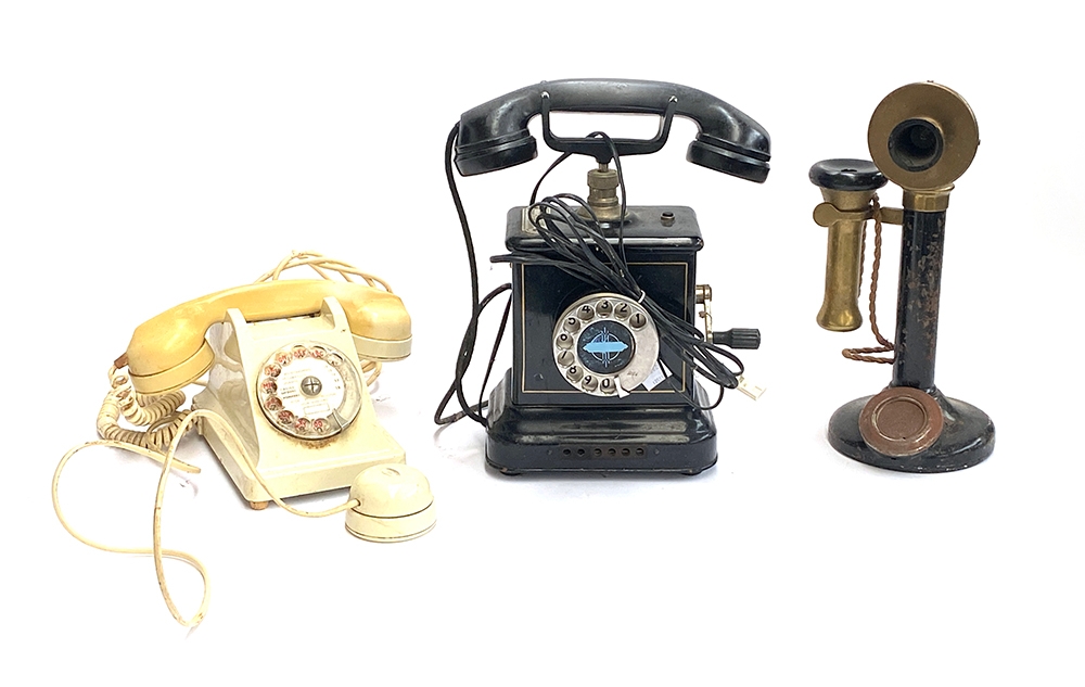 Three vintage telephones: A 1950s ivory coloured French rotary dial, a candlestick telephone, and
