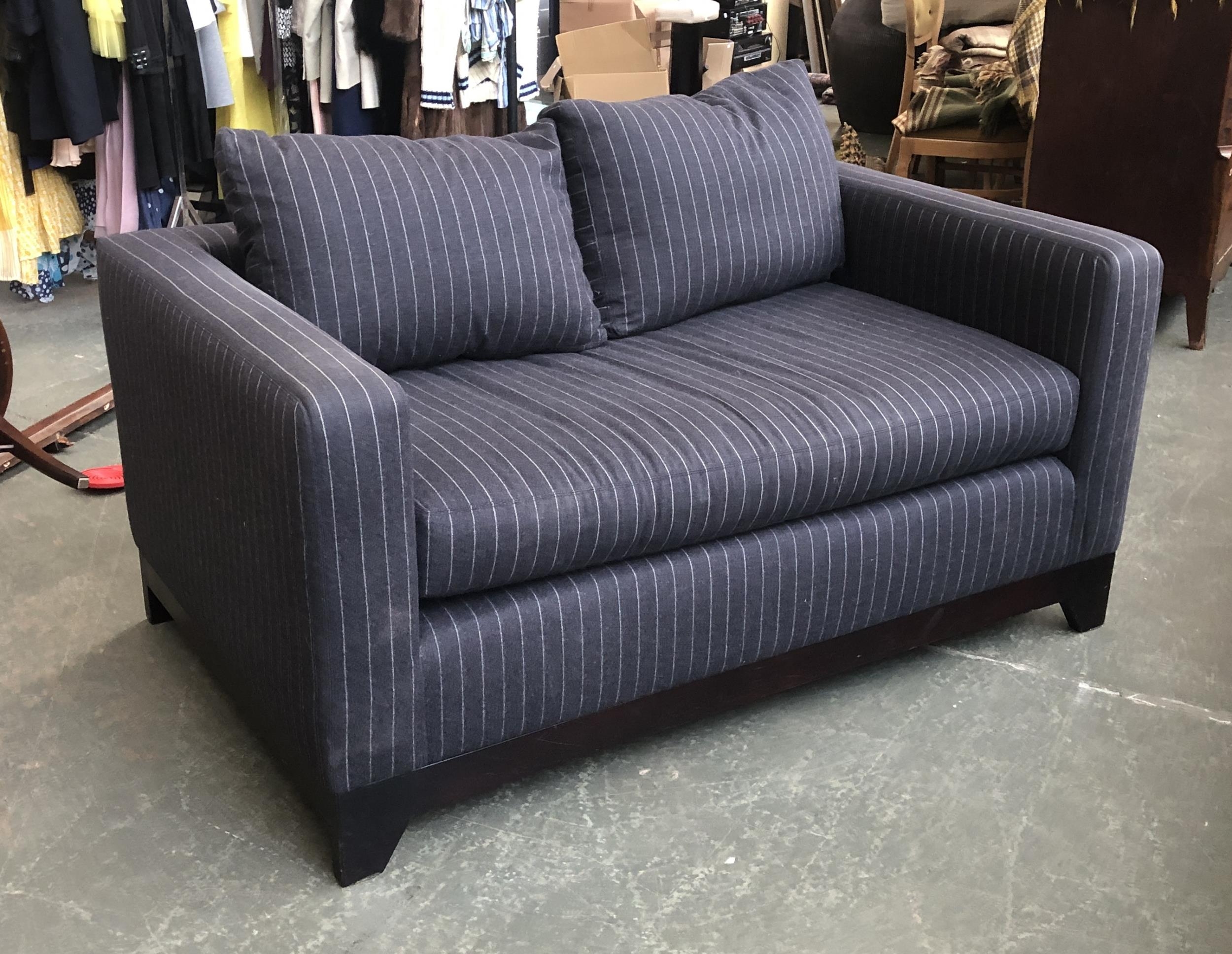 A contemporary two seater sofa, upholstered in a black pinstripe fabric, small holes in main cushion