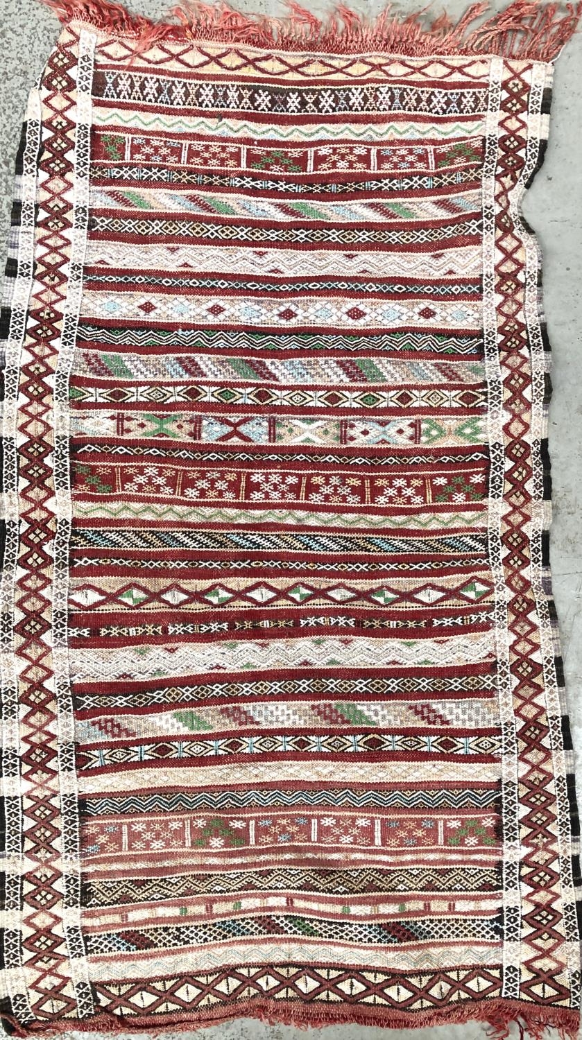 A small striped Moroccan rug, 109x64cm