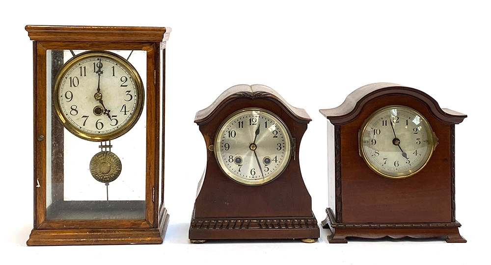 Three early 20th century mantel clocks, one in a glass case, 30cmH